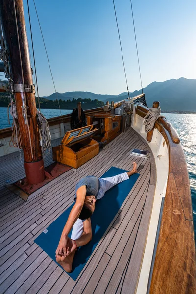 Man praktiserar Yoga på en segelbåt — Stockfoto