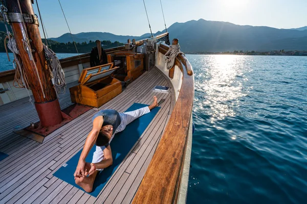 Man praktiserar Yoga på en segelbåt — Stockfoto