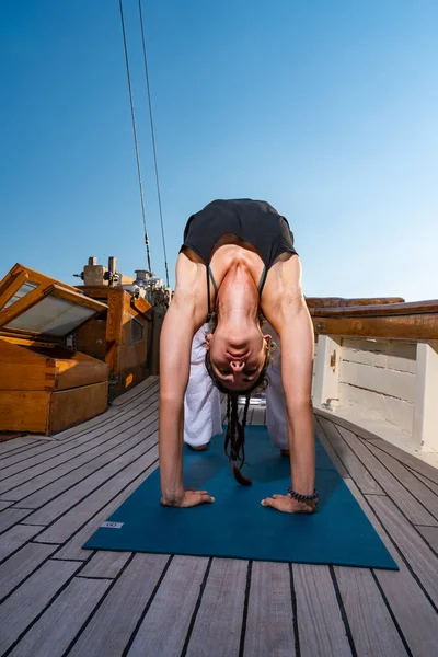 Kvinna praktiserar Yoga på en segelbåt — Stockfoto