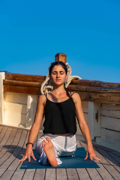 Frau praktiziert Yoga auf einer Segeljacht — Stockfoto