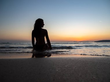 Kadın tropik plajda güneşleniyor.