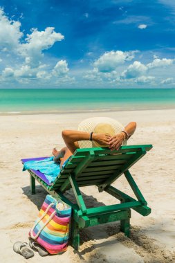 Beyaz kumsalda güneşlenen bir kadın İnanılmaz tropikal kumsalda 