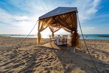 Bali 'de gün batımında sahilde akşam yemeği masası.