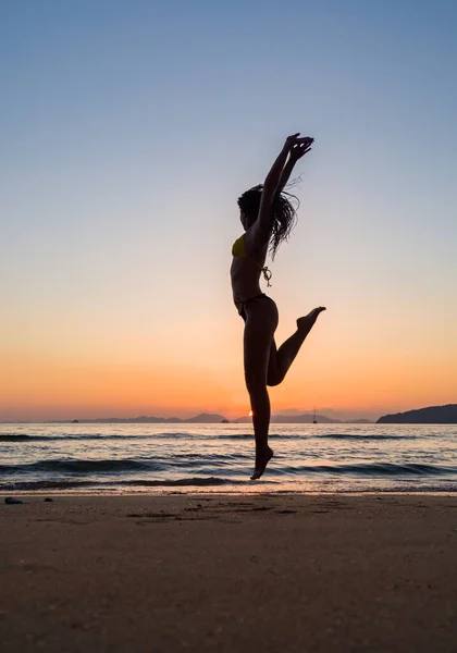 Gün Batımında Mayo Giymiş Bir Kadın Kumsalda Zıplıyor — Stok fotoğraf