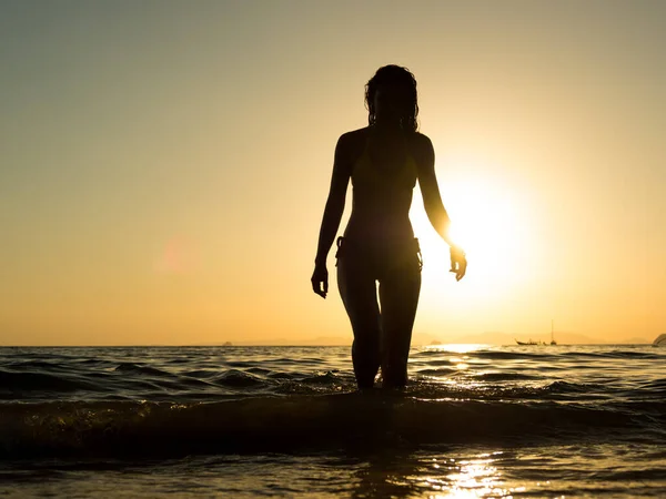 日落时穿着泳衣在海滩上摆姿势的女人 — 图库照片