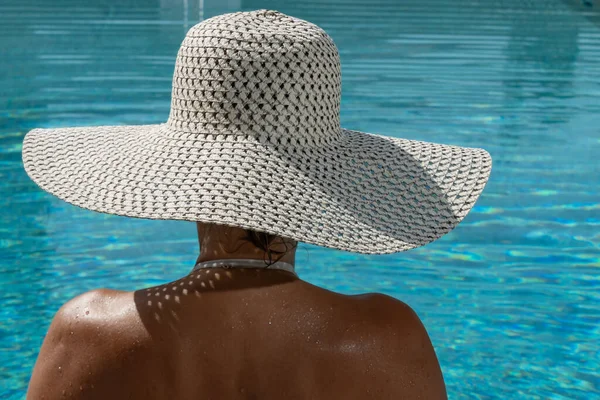スイミングプールのそばにある5つ星のスパリゾートで藁帽子を被った女性 — ストック写真