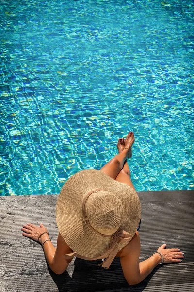 水泳プールのデッキに座っている女性 — ストック写真