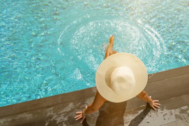 Yunanistan 'ın Santorini adasındaki yüzme havuzunda, Caldera manzaralı lüks bir tatil yapan bir kadın.