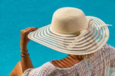 Beş yıldızlı bir kaplıcada, havuz kenarında, iskelede oturan bir kadın.. 