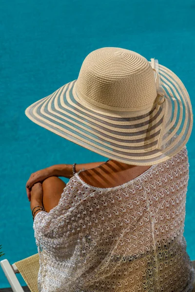 女人坐在游泳池边的豪华五星级温泉度假胜地的躺椅上 — 图库照片