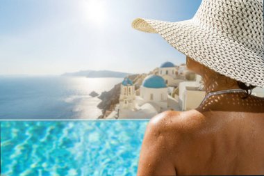 Yunanistan 'ın Santorini adasındaki yüzme havuzunda, Caldera manzaralı lüks bir tatil yapan bir kadın.