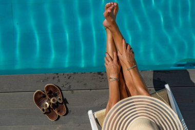 Beş yıldızlı bir kaplıcada, havuz kenarında, iskelede oturan bir kadın.. 