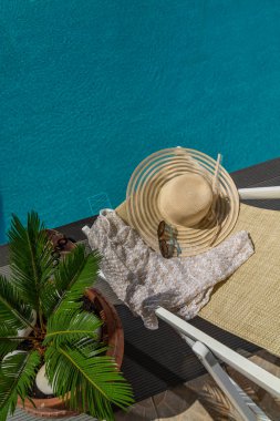 Lüks havuz kenarındaki beş yıldızlı spa merkezinde hasır şapka ve iskele sandalyesi.. 