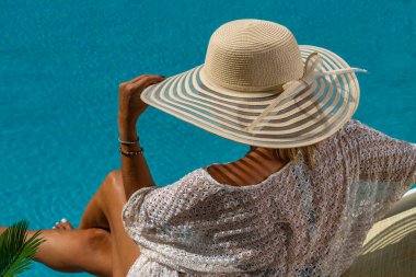 Beş yıldızlı bir kaplıcada, havuz kenarında, iskelede oturan bir kadın.. 