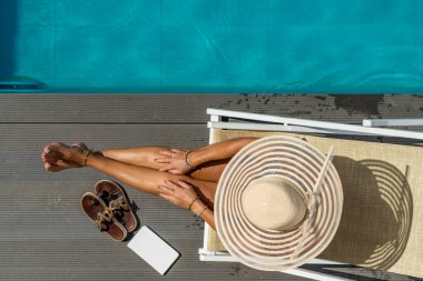 Beş yıldızlı bir kaplıcada, havuz kenarında, iskelede oturan bir kadın.. 