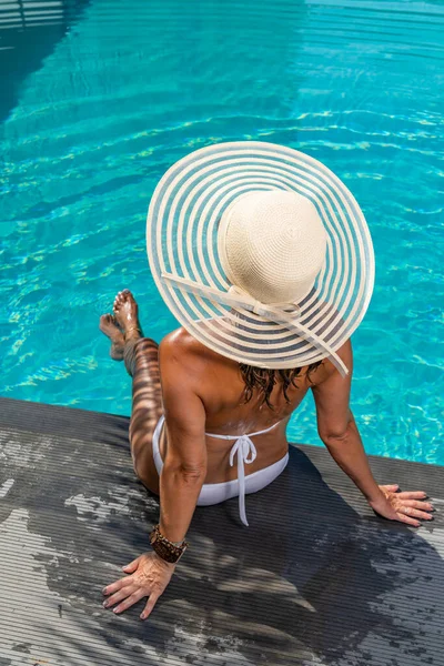 スイミングプールのそばにある5つ星のスパリゾートで藁帽子を被った女性 — ストック写真