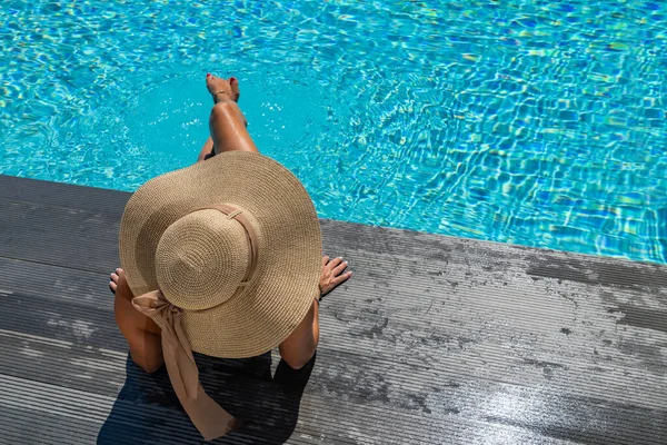 Kadın yüzme havuzunda güvertede oturuyor.