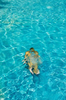 Yüzme havuzunda bikinili bir kadın suyun altında 