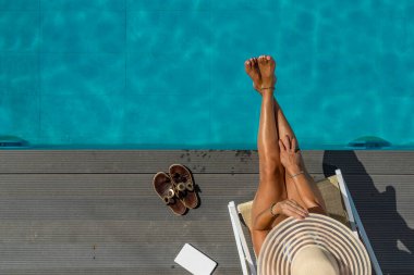 Beş yıldızlı bir kaplıcada, havuz kenarında, iskelede oturan bir kadın.. 