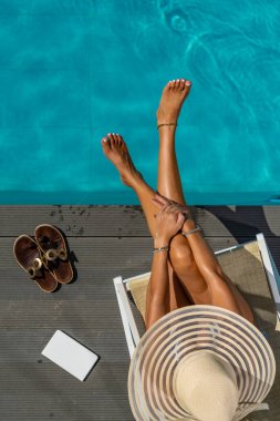 Beş yıldızlı bir kaplıcada, havuz kenarında, iskelede oturan bir kadın.. 