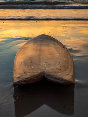 Gün batımında sahilde sörf tahtası