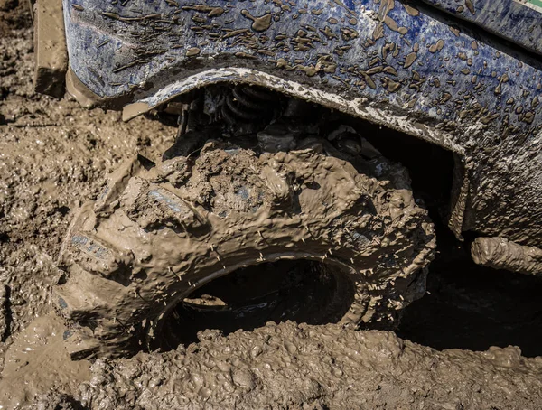 Wheels of off road car stuck full of mud