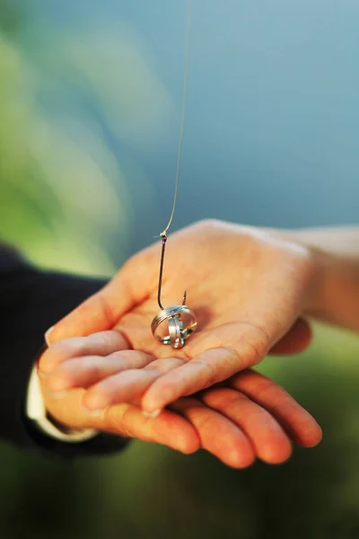 Hochzeitspaar Hält Angelhaken Und Ehering — Stockfoto