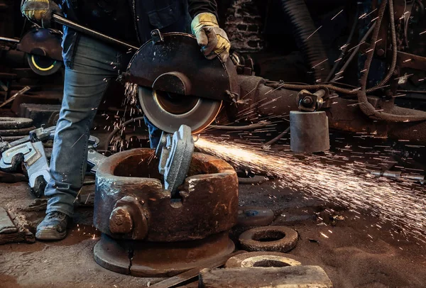 Worker cut metal with angle grinder