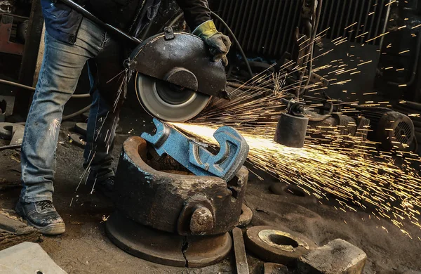 Worker cut metal with angle grinder