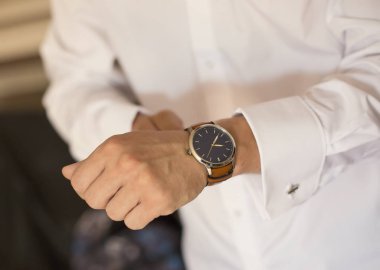 Elindeki saati tamir eden genç adam.