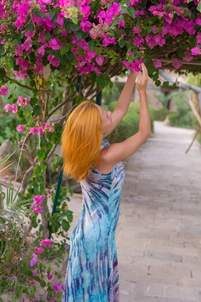 Jovem mulher vermelha com flores — Fotografia de Stock