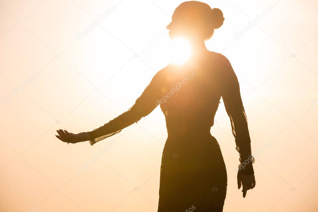 Woman dancing at sunrise