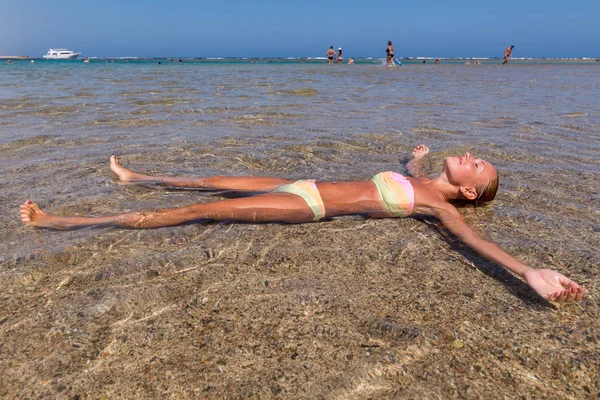 Schöne Frau, die im Meer liegt — Stockfoto