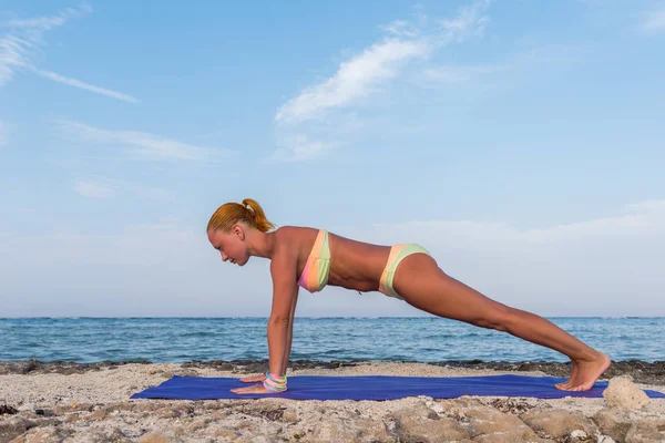 Sottile donna che pratica posa tavola — Foto Stock