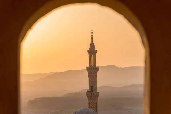 Matahari terbenam di atas gurun dengan masjid Muslim di latar depan — Stok Foto