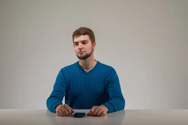 Trieste jonge man aan tafel — Stockfoto