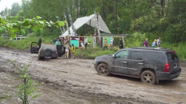 SUV atascado camino fangoso en el festival — Vídeo de stock