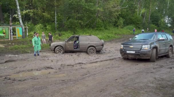 Автомобиль, проезжающий по грязной дороге на фестивале — стоковое видео