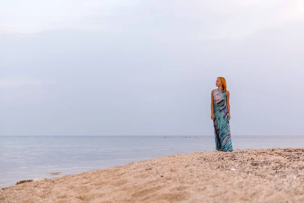 Jonge rode vrouw op een strand — Stockfoto