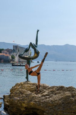 Heykelin yanında poz veren bir turist