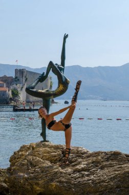 Heykelin yanında poz veren bir turist