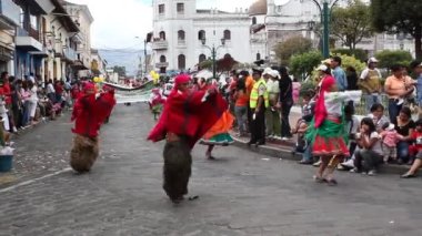 Şehir caddesinde geçit töreni videosu, yolda dans eden ve geleneksel kostümler giyen insanlar. 
