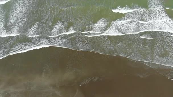 Vue aérienne des vagues se brisant sur la plage de sable, vidéo au ralenti 