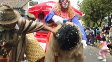 Şehir caddesinde geçit töreni videosu, yolda dans eden ve geleneksel kostümler giyen insanlar. 