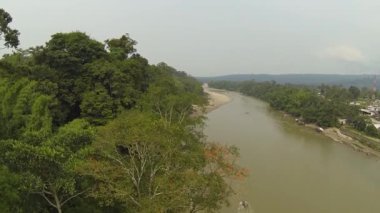 Orman ağaçları ve nehir akıntısı videosu, Ekvador Amazon 'daki köy binaları.