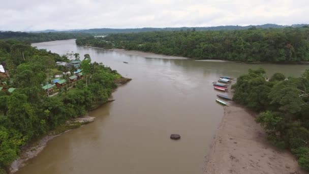 木と茶色の川の水がボートで流れる村の風景の空撮ビデオ — ストック動画