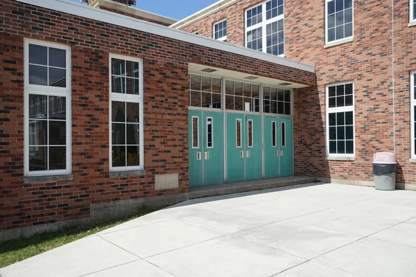 Green doors for a red brick building — Stock Photo, Image