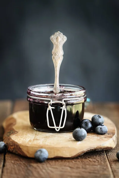 自制的蓝莓保存在罐头玻璃保释罐与古董勺子 具有选择性聚焦于果酱的极浅景深场 — 图库照片