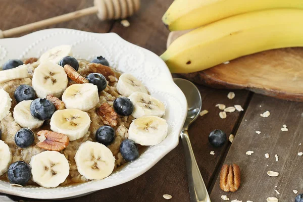 Hot Breakfast Healthy Oatmeal Pecans Bananas Blueberries Honey Rustic Background — Stock Photo, Image