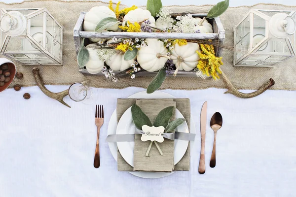予約感謝祭やハロウィーンの場所の設定はミニ白カボチャ入り農家のテーブルで 子羊の耳の葉 アントラーズと秋の野の花 — ストック写真